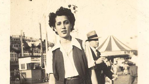 A woman stands on the Coney Island boardwalk.